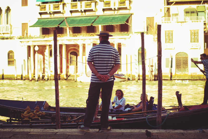 A lone gondolier on a canal bank in Venice